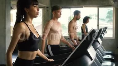 一群人在现代健身房的跑步机上锻炼。 健身男女一起工作